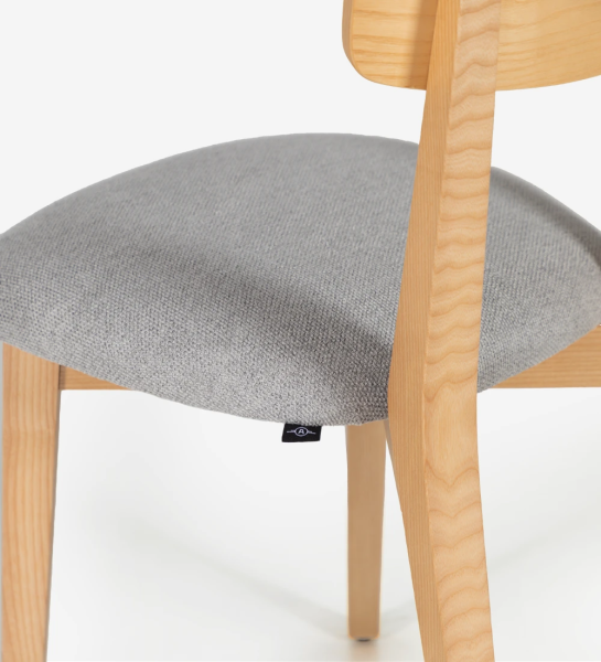 Chaise en bois de frêne naturel avec assise rembourrée en tissu.