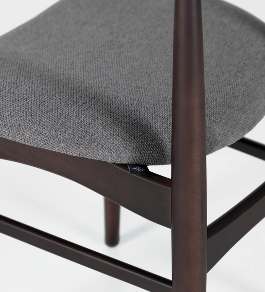Chaise en bois de frêne couleur brun foncé avec assise recouverte de tissu.
