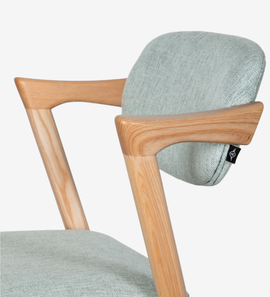 Tabouret en bois de frêne couleur naturel, avec assise et dossier rembourrés en tissu.