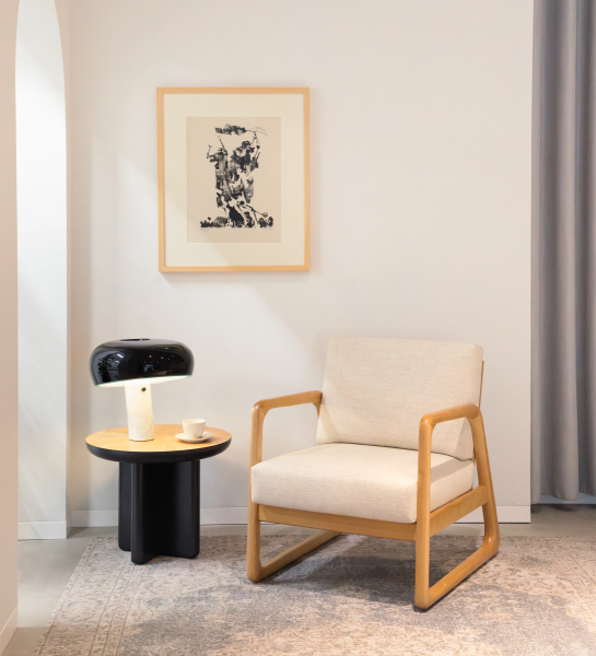 Fauteuil Antarte by IA recouvert en tissu beige, structure en bois naturel.