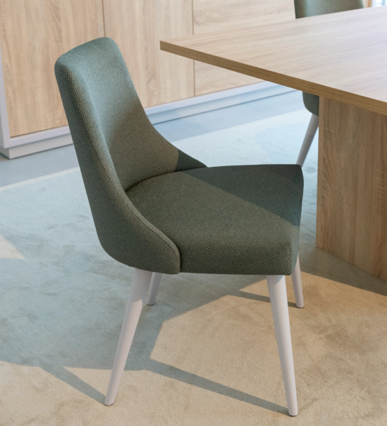 Oslo chair upholstered in green fabric, pearl lacquered feet.