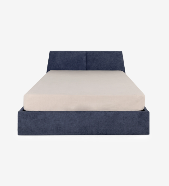 Cama doble Oslo con cabecero y pie de cama tapizados en tela azul, laterales en roble natural, almacenaje mediante plataforma elevadora.