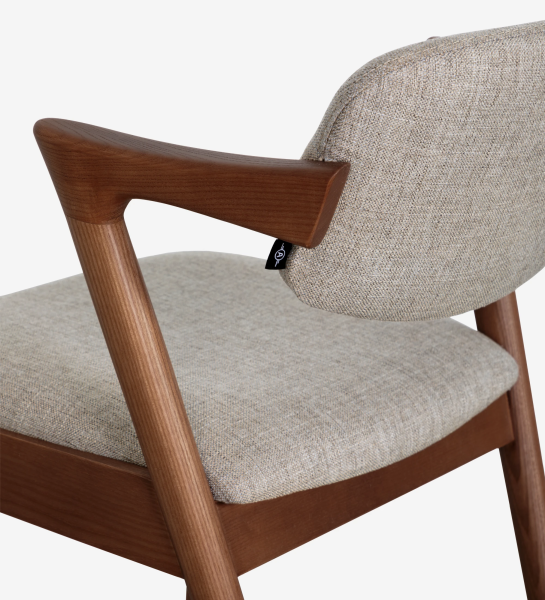 Silla en madera de fresno color nogal, con asiento y respaldo tapizado en tejido.