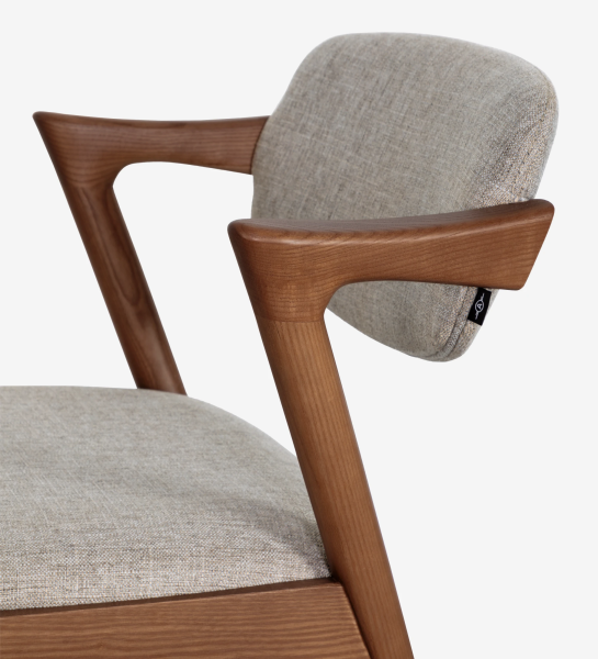 Silla en madera de fresno color nogal, con asiento y respaldo tapizado en tejido.