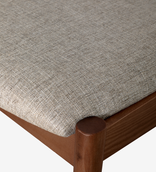 Silla en madera de fresno color nogal, con asiento y respaldo tapizado en tejido.