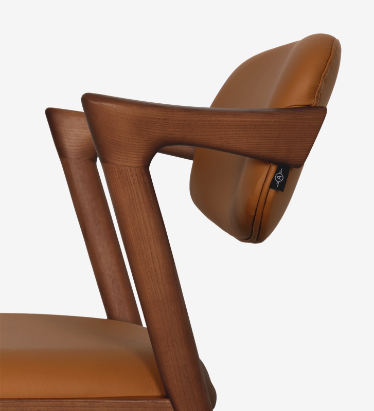 Taburete en madera de fresno color nogal, con asiento y respaldo tapizado en piel.