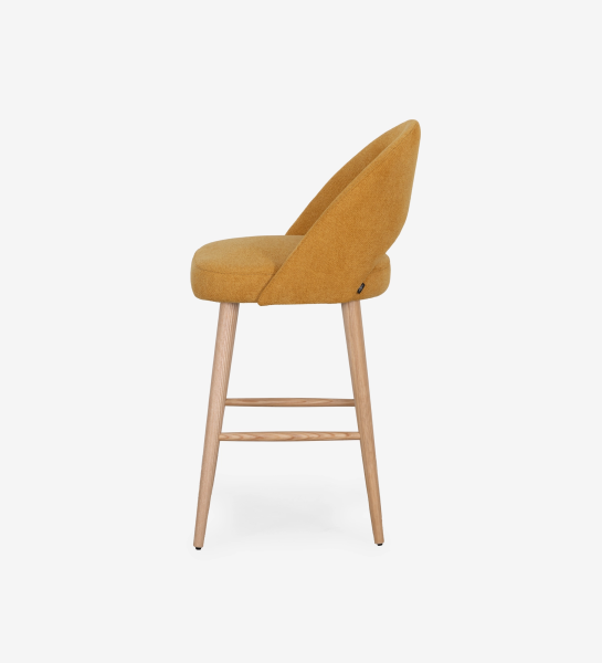 Stool upholstered in yellow fabric, with natural colored wooden legs.