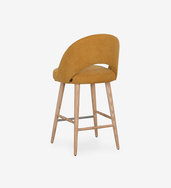 Stool upholstered in yellow fabric, with natural colored wooden legs.