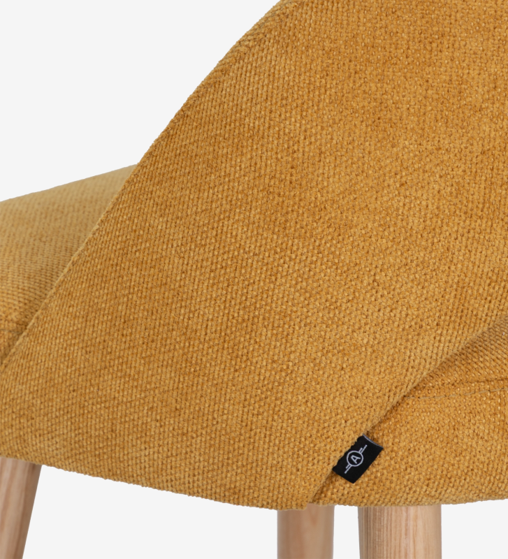 Banco tapizado en tela amarilla, con patas de madera color natural.