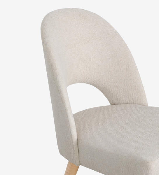 Chair upholstered in beige fabric, with natural colored wooden legs.