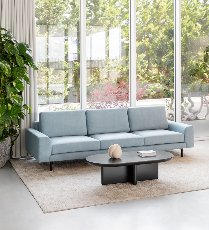 Canapé Oslo 3 places recouvert en tissu bleu, pieds laqués marron foncé, 265 cm.