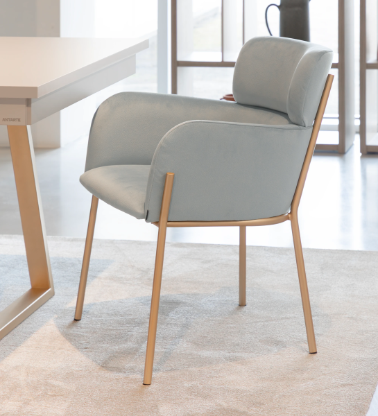 Chaise avec accoudoirs rembourrée en tissu bleu, avec structure métallique laquée en doré.
