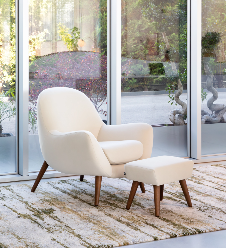 Oslo armchair upholstered in pearl fabric with walnut-stained ash wood legs.