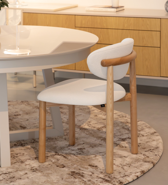 Silla de madera de fresno en color natural, con asiento y respaldo tapizados en tejido blanco.