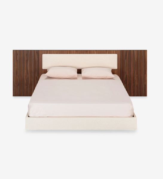 Lit double avec panneau central de la tête de lit et base suspendue revêtus de tissu beige, côtés de la tête de lit avec frises en noyer naturel.