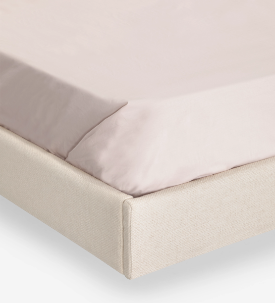 Lit double avec panneau central de la tête de lit et base suspendue revêtus de tissu beige, côtés de la tête de lit avec frises en noyer naturel.