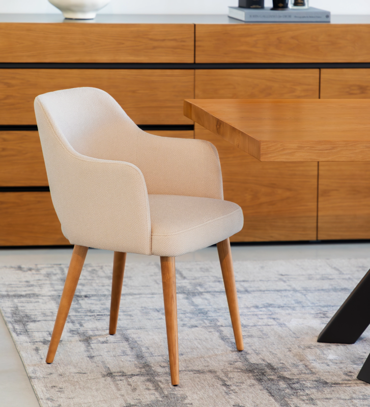 Armchair upholstered in beige fabric, with honey-colored wooden legs.