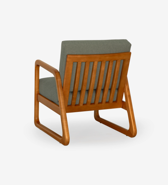 Sillón Antarte by IA tapizado en tela verde, estructura en madera color miel.