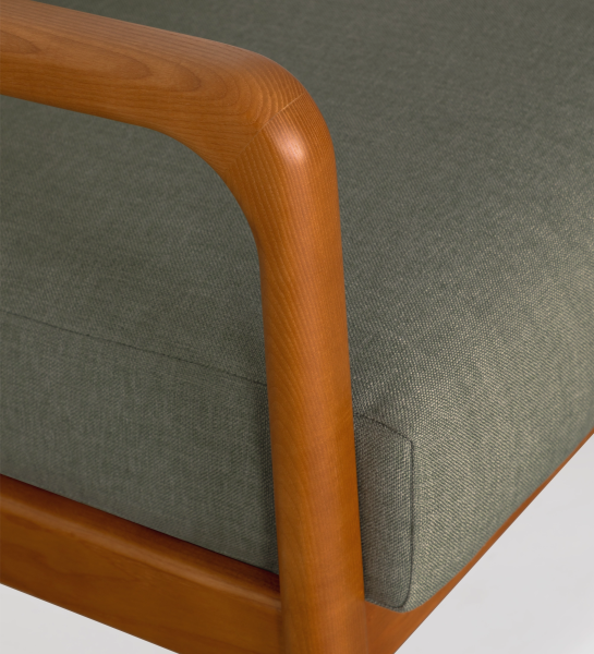 Sillón Antarte by IA tapizado en tela verde, estructura en madera color miel.