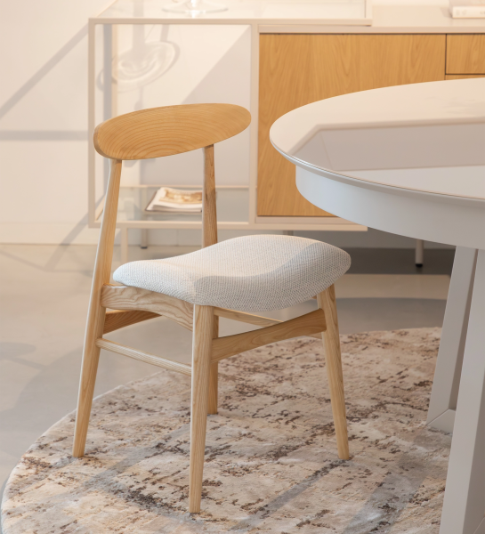 Silla de madera de fresno, color natural con asiento tapizado en tejido perla.