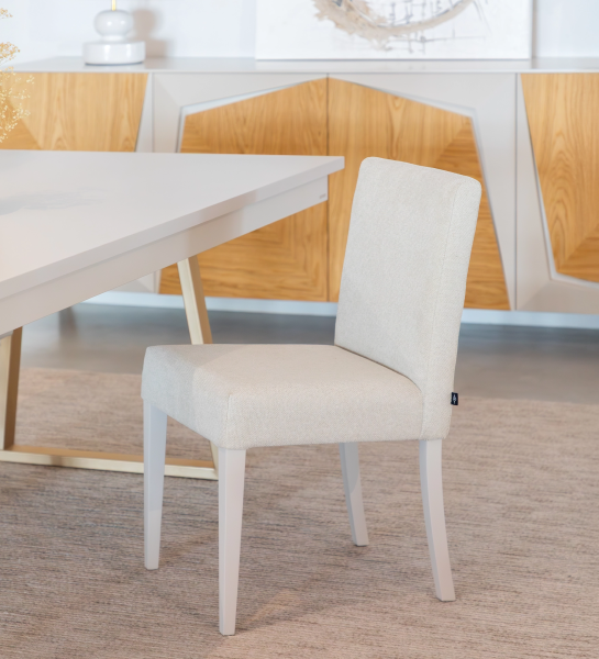 Chaise rembourrée en tissu, pieds laqués perle.
