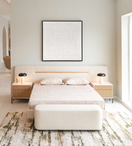 Double bed with upholstered headboard and suspended base in beige fabric, detailed in natural oak.