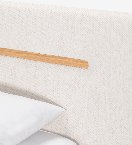 Double bed with upholstered headboard and suspended base in beige fabric, detailed in natural oak.