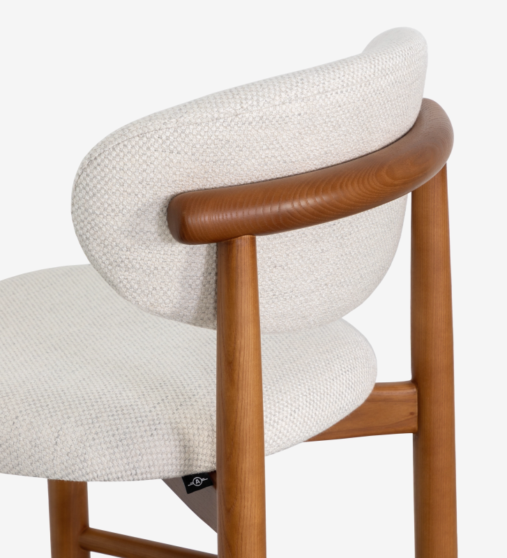 Stool in honey-colored ash wood, with seat and backrest upholstered in pearl fabric.