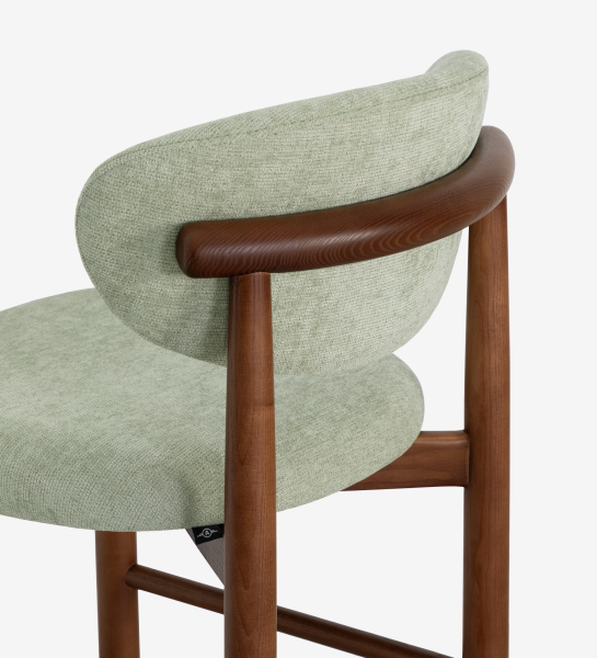 Tabouret en bois de frêne couleur noyer, avec assise et dossier rembourrés en tissu vert.