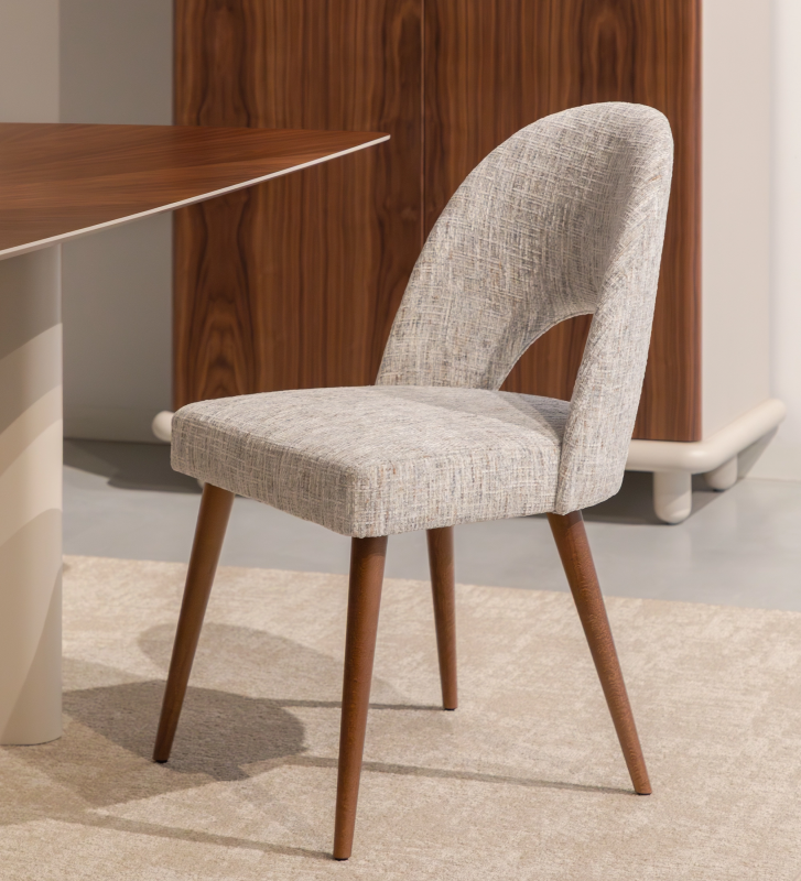 Chair upholstered in gray velvety fabric, with walnut-colored wooden legs.