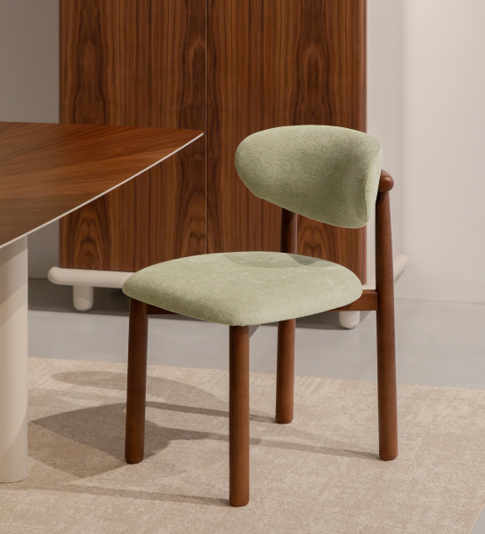 Chaise Nice en tissu vert clair avec pieds en bois foncé et dossier arrondi
