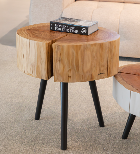 Mesa Auxiliar Tronco de madera con tres patas negras y libro encima