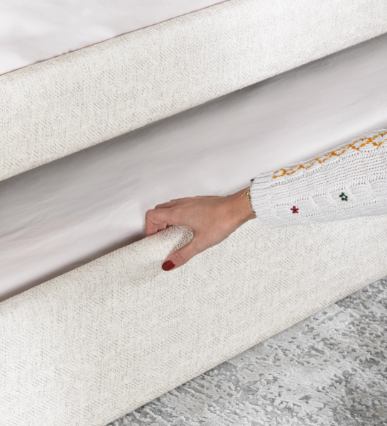 Divan Bed with upholstered frame and front in pearl fabric, featuring a bed in the lower drawer.