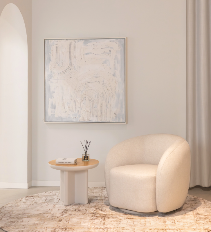 Sillón con base giratoria y completamente tapizado en tejido color perla.