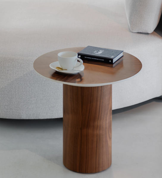 Table d'Appui Paris ronde en bois avec tasse et livre près d'un canapé gris