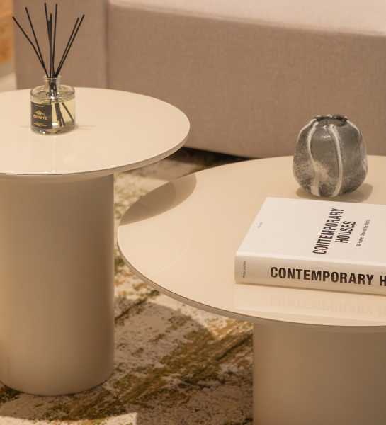 Paris Center Table set with two round cream glossy tables topped with book, vase and diffuser