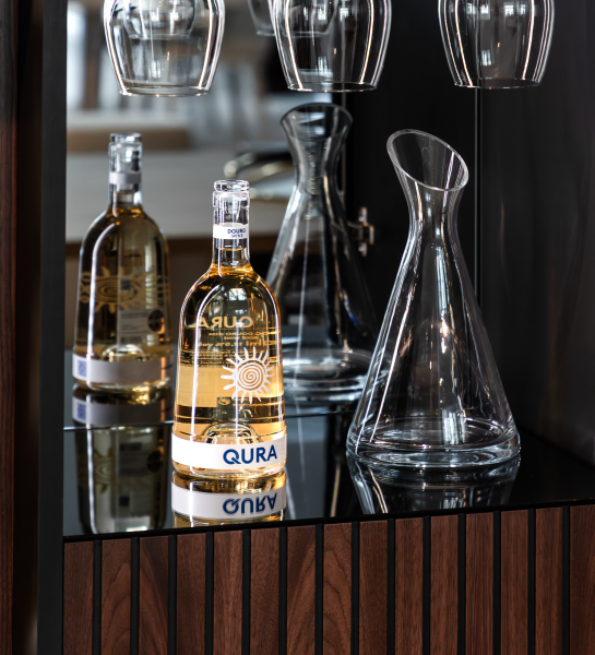 Vinoteca Cannes con botella de vino, decantador y copas sobre mueble de madera