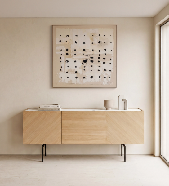 Buffet Lagos en bois clair à trois portes sur pieds métalliques, vase et livres dessus