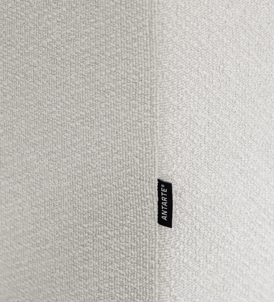 Sofá Lagos, primer plano de tejido bouclé beige con etiqueta negra